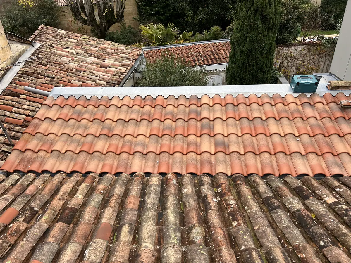 Raccord de toiture en tuiles contre un mur
